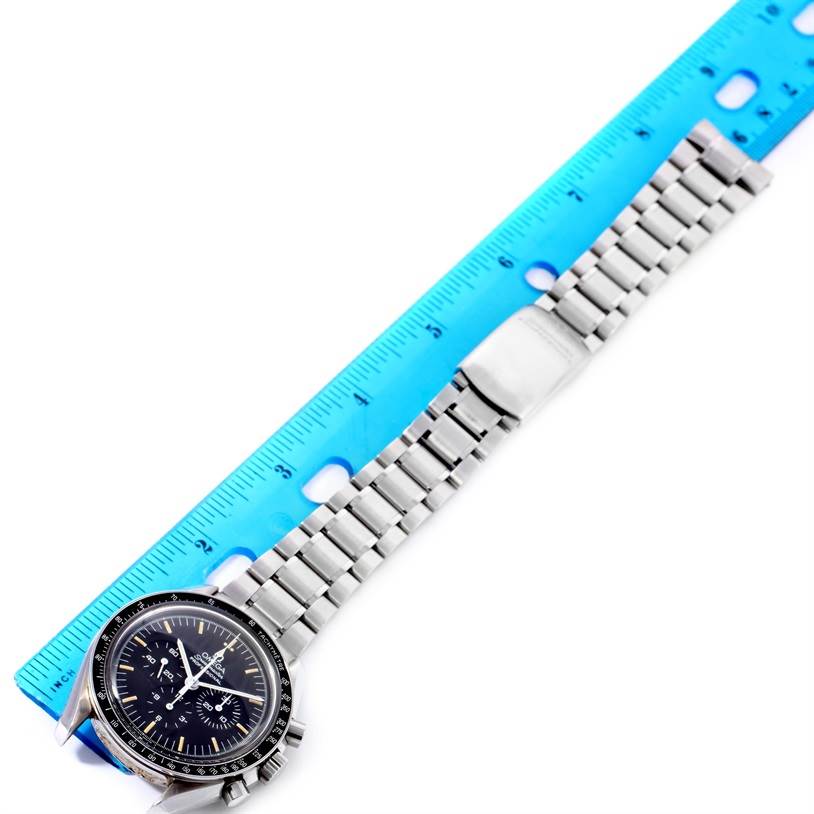 This image shows an Omega Speedmaster 3572.50.00 Men's Stainless Steel Black Dial 3572.50.00 Men's Stainless Steel Black Dial watch at an angled top view, measured against a blue ruler.