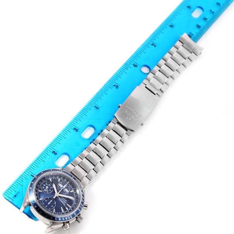 The Omega Speedmaster 3222.80.00 Men
s Stainless Steel Blue Dial 3222.80.00 Men
s Stainless Steel Blue Dial watch is shown flat with its face, bezel, and metal bracelet next to a blue ruler.