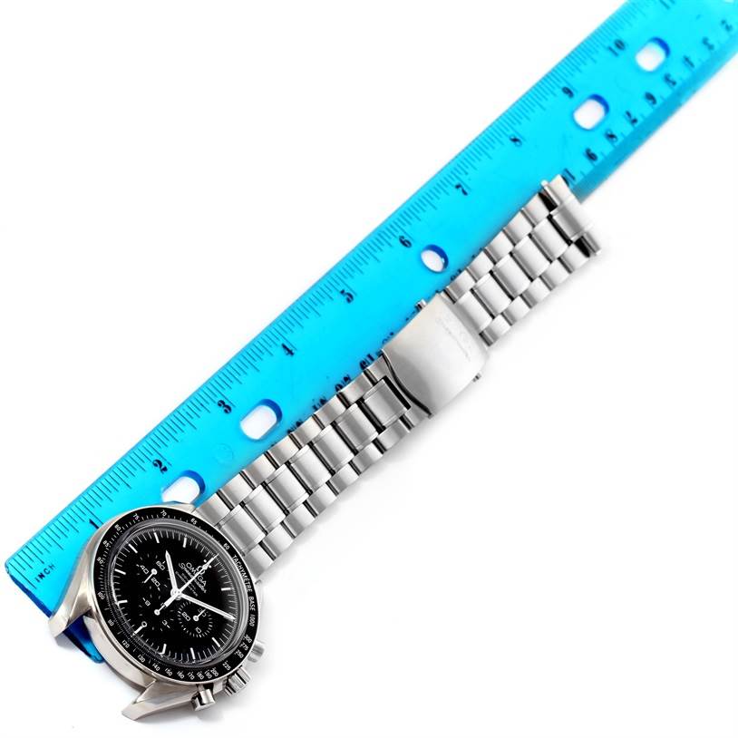 The image shows an Omega Speedmaster 311.30.44.50.01.002 Men
s Stainless Steel Black Dial 311.30.44.50.01.002 Men
s Stainless Steel Black Dial watch laid flat, with its metal band extended along a blue ruler, displaying the face and bracelet.