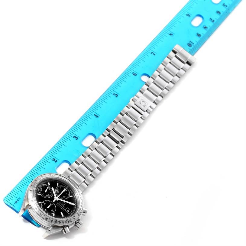 The image shows an Omega Speedmaster 3513.50.00 Men
s Stainless Steel Black Dial 3513.50.00 Men
s Stainless Steel Black Dial watch laid flat with its metal bracelet extended next to a blue ruler.