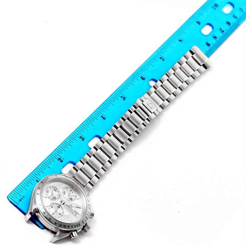 The Omega Speedmaster 3513.30.00 Men's Stainless Steel Silver Dial 3513.30.00 Men's Stainless Steel Silver Dial watch is shown from the front, positioned beside a blue ruler, displaying the face and metal bracelet.