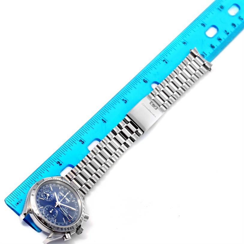 The image shows the full front view of an Omega Speedmaster 3521.80.00 Men
s Stainless Steel Blue Dial 3521.80.00 Men
s Stainless Steel Blue Dial watch alongside a ruler.