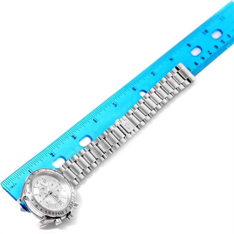 The image shows an Omega Speedmaster 3513.30.00 Men's Stainless Steel Silver Dial 3513.30.00 Men's Stainless Steel Silver Dial watch lying flat with its bracelet next to a blue ruler for scale.