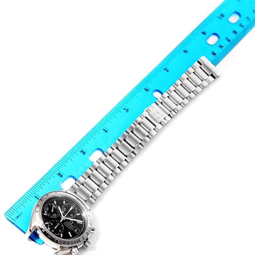 The image shows an Omega Speedmaster 3513.50.00 Men
s Stainless Steel Black Dial 3513.50.00 Men
s Stainless Steel Black Dial watch laid next to a ruler, displaying its linked metal bracelet and watch face at an oblique angle.