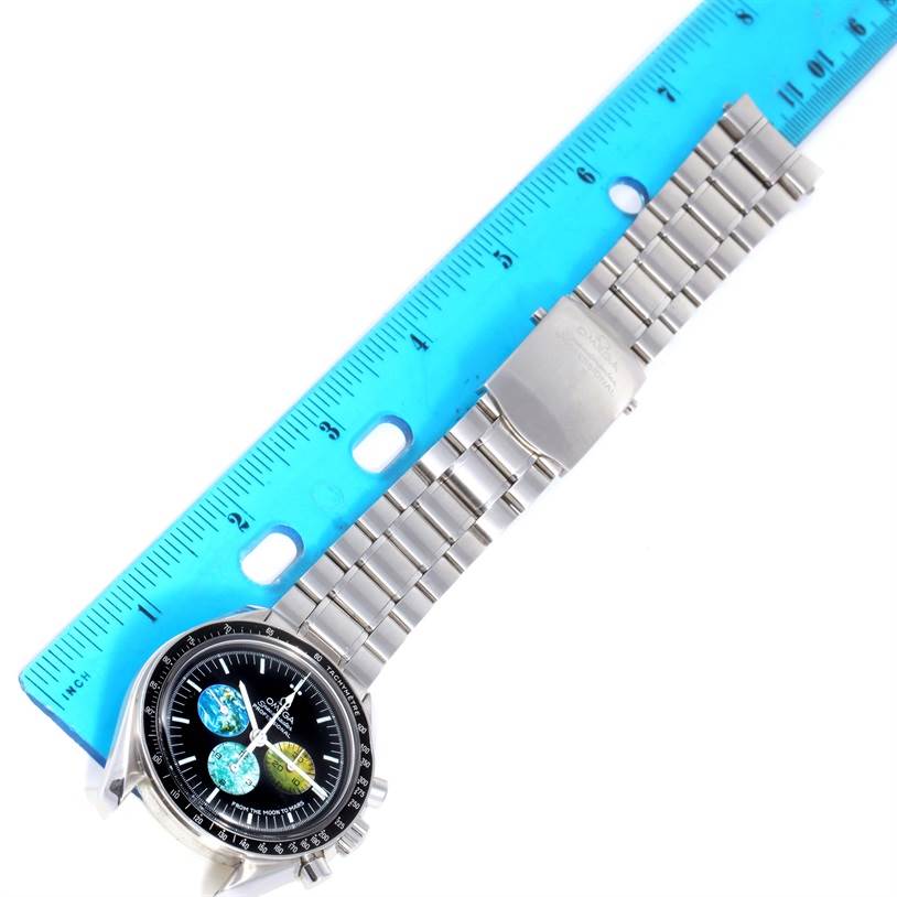 The Omega Speedmaster 3577.50.00 Men's Stainless Steel Black Dial 3577.50.00 Men's Stainless Steel Black Dial watch is shown from a top angle, including the face, bezel, and metal bracelet with a ruler beside it.