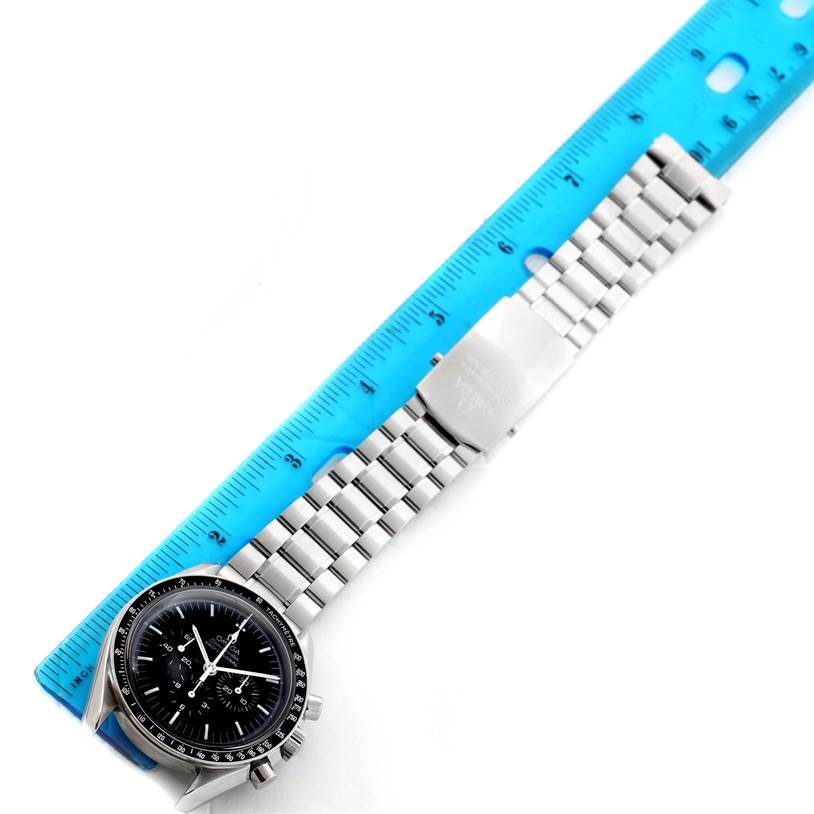 The image shows an Omega Speedmaster 3570.50.00 Men
s Stainless Steel Black Dial 3570.50.00 Men
s Stainless Steel Black Dial watch laid flat with its stainless steel bracelet next to a blue ruler.