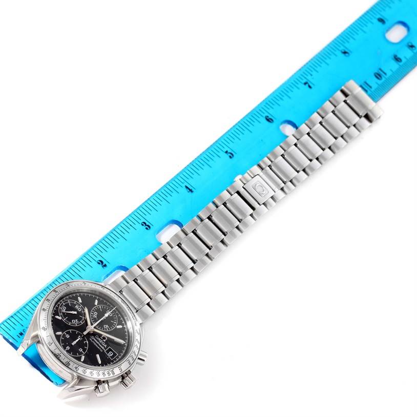 The Omega Speedmaster 3513.50.00 Men
s Stainless Steel Black Dial 3513.50.00 Men
s Stainless Steel Black Dial watch is shown from a diagonal angle, displaying the face, stainless steel band, and a blue ruler for scale.