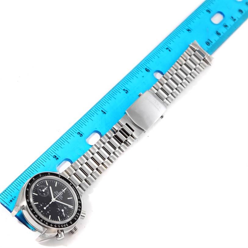 The image shows an Omega Speedmaster 3539.50.00 Men
s Stainless Steel Black Dial 3539.50.00 Men
s Stainless Steel Black Dial watch lying flat, featuring its face, bezel, and metal bracelet next to a blue ruler.