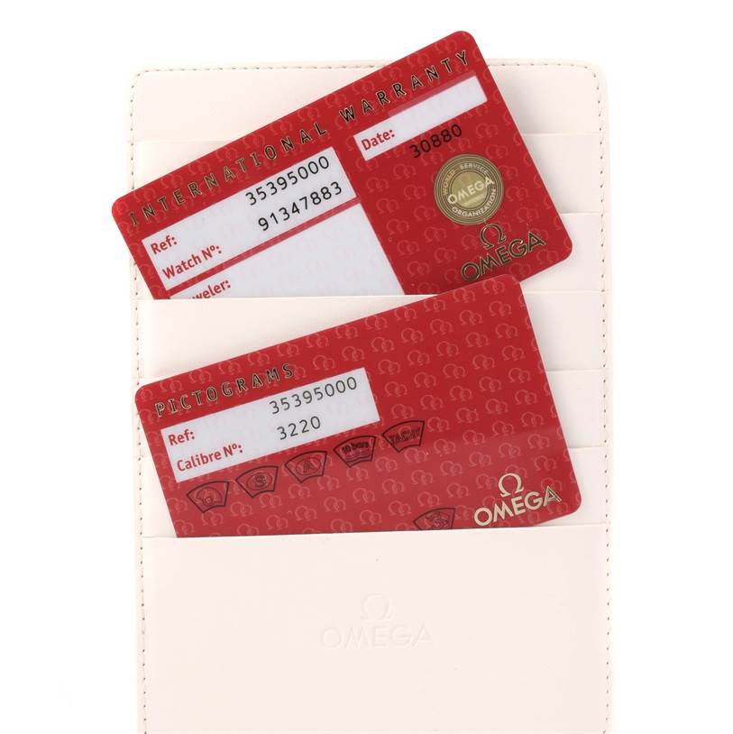 The image shows two red Omega Speedmaster 3539.50.00 Men
s Stainless Steel Black Dial 3539.50.00 Men
s Stainless Steel Black Dial international warranty cards inside a beige holder.