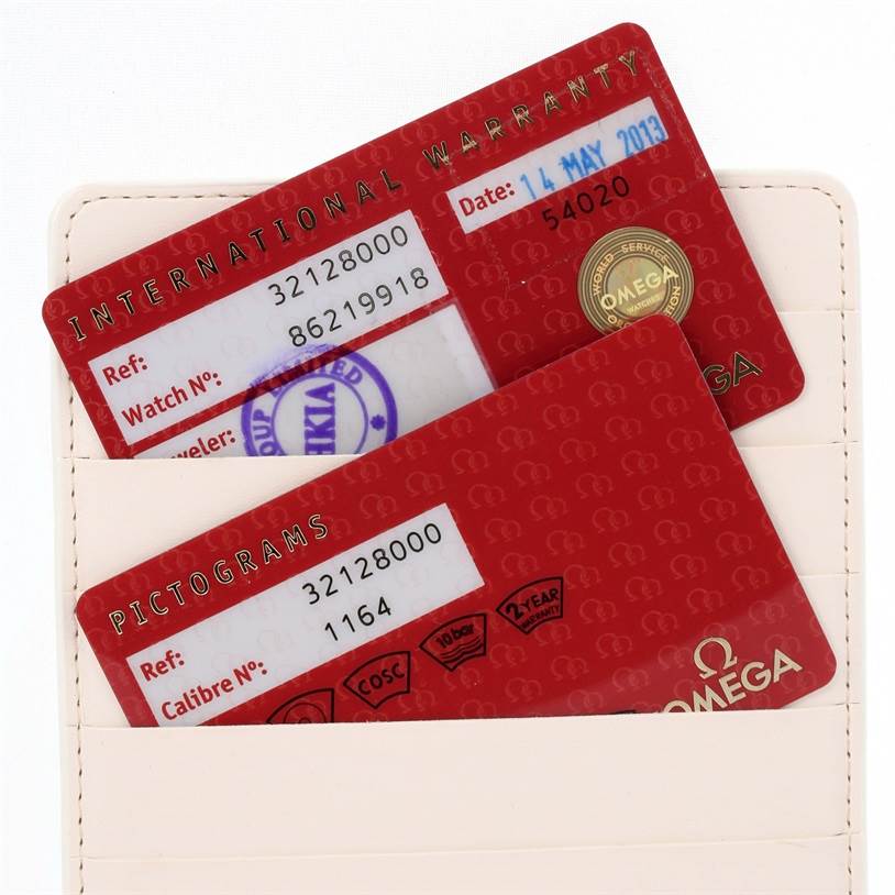 The image shows the International Warranty and Pictograms cards for an Omega Speedmaster 3212.80.00 Men
s Stainless Steel Blue Dial 3212.80.00 Men
s Stainless Steel Blue Dial watch, partially inside a card holder.