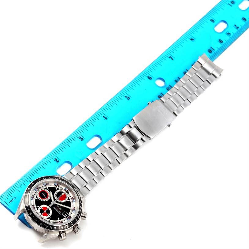 The image shows an Omega Speedmaster 3210.52.00 Men
s Stainless Steel Black Dial 3210.52.00 Men
s Stainless Steel Black Dial watch placed next to a blue ruler, highlighting the face and metal bracelet.