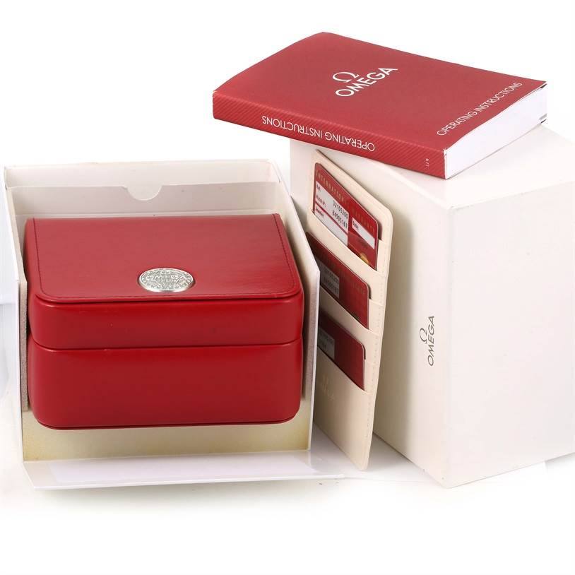 The image shows the packaging of an Omega Speedmaster 3210.52.00 Men
s Stainless Steel Black Dial 3210.52.00 Men
s Stainless Steel Black Dial watch, including a red box, instruction manual, and warranty cards.