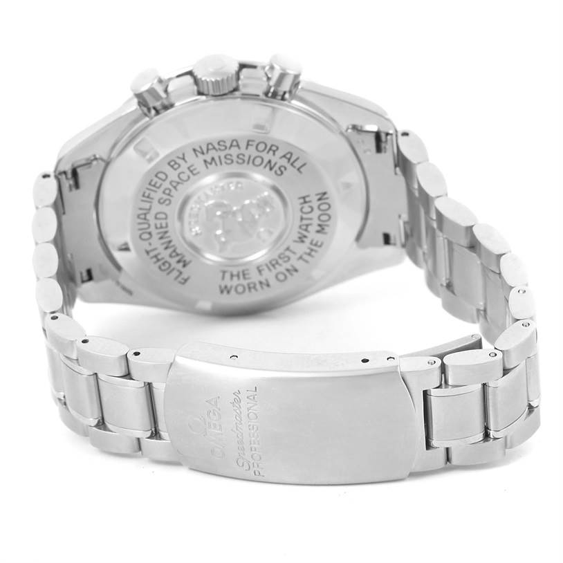 The image shows the back case and bracelet of an Omega Speedmaster 3570.50.00 Men
s Stainless Steel Black Dial 3570.50.00 Men
s Stainless Steel Black Dial watch, showcasing its inscriptions and clasp.