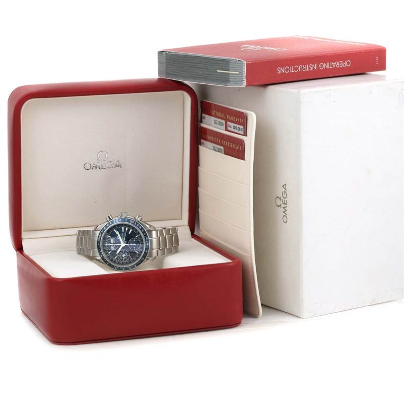 The Omega Speedmaster 3222.80.00 Men
s Stainless Steel Blue Dial 3222.80.00 Men
s Stainless Steel Blue Dial watch is displayed in its open box along with warranty cards and an operating instructions booklet.