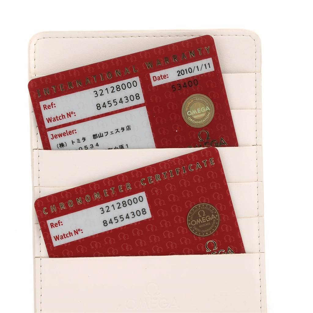 The image shows two red Omega Speedmaster 3212.80.00 Men
s Stainless Steel Blue Dial 3212.80.00 Men
s Stainless Steel Blue Dial warranty and certificate cards in a white cardholder.