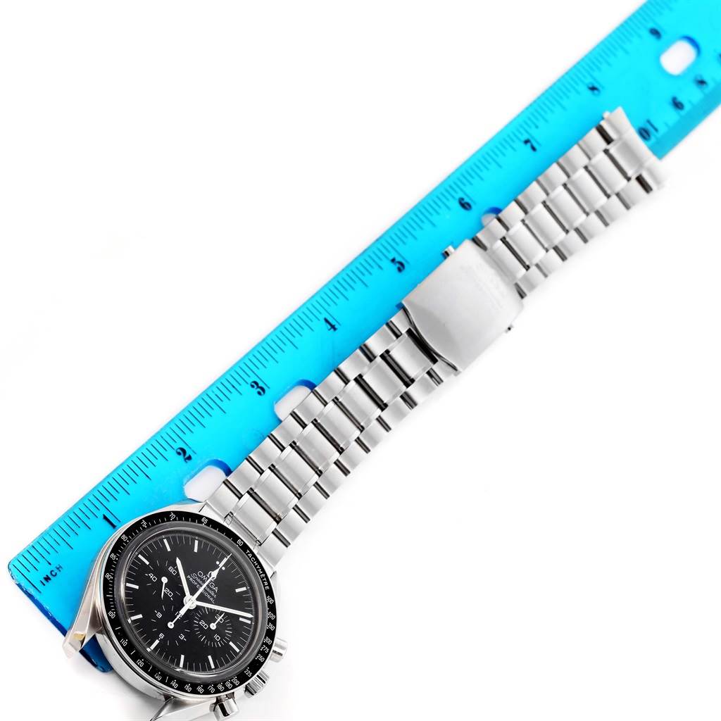 The Omega Speedmaster 3573.50.00 Men
s Stainless Steel Black Dial 3573.50.00 Men
s Stainless Steel Black Dial watch is shown flat, highlighting its face, bezel, and metal bracelet next to a blue ruler.