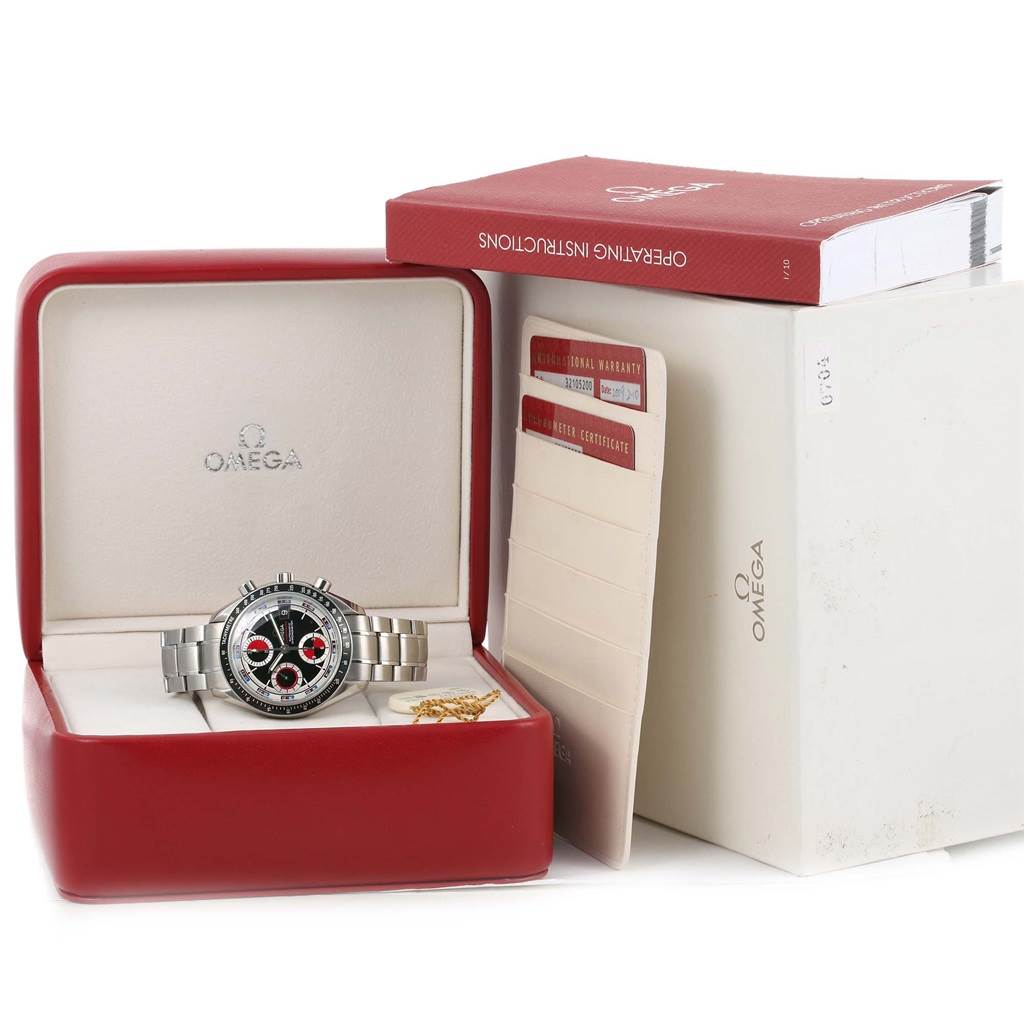 The Omega Speedmaster 3210.52.00 Men
s Stainless Steel Black Dial 3210.52.00 Men
s Stainless Steel Black Dial watch is shown from the front in its open box, alongside the instruction manual and warranty cards.