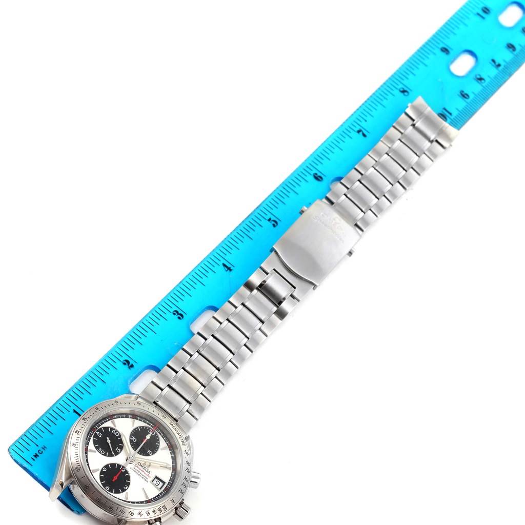 The image shows an Omega Speedmaster 3211.31.00 Men
s Stainless Steel Silver Dial 3211.31.00 Men
s Stainless Steel Silver Dial watch placed next to a ruler, showcasing its face, bezel, and metal bracelet.