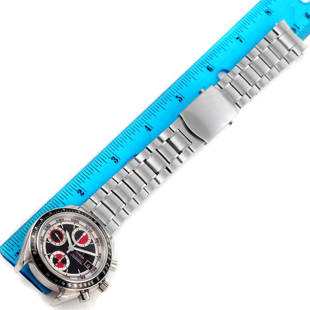 The image shows an Omega Speedmaster 3210.52.00 Men
s Stainless Steel Black Dial 3210.52.00 Men
s Stainless Steel Black Dial watch, displaying its face and entire metal bracelet next to a blue ruler.