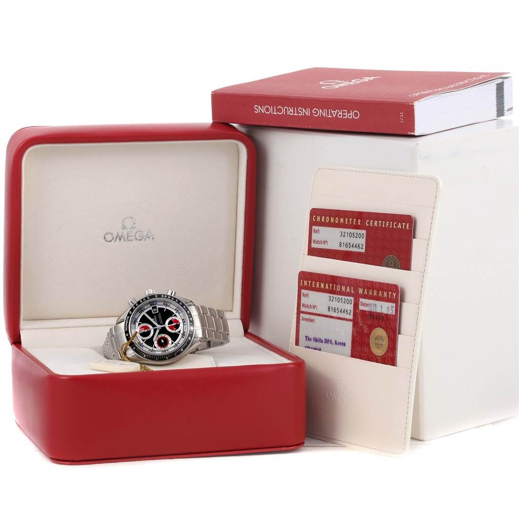 The Omega Speedmaster 3210.52.00 Men
s Stainless Steel Black Dial 3210.52.00 Men
s Stainless Steel Black Dial watch is shown at an angle inside its open box, accompanied by warranty cards and an instruction manual.