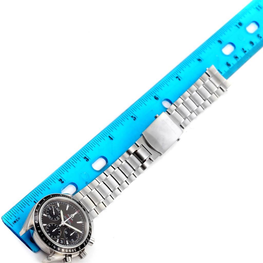 The image shows an Omega Speedmaster 323.30.40.40.06.001 Men
s Stainless Steel Grey Dial 323.30.40.40.06.001 Men
s Stainless Steel Grey Dial watch and stainless steel bracelet next to a blue ruler, viewed from above.