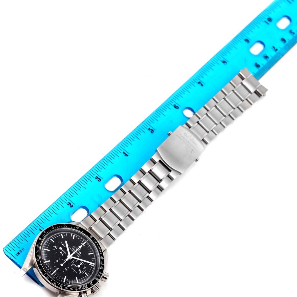 The Omega Speedmaster 311.30.42.30.01.005 Men
s Stainless Steel Black Dial 311.30.42.30.01.005 Men
s Stainless Steel Black Dial watch is shown from a top-down angle with a blue ruler next to it for measurement.