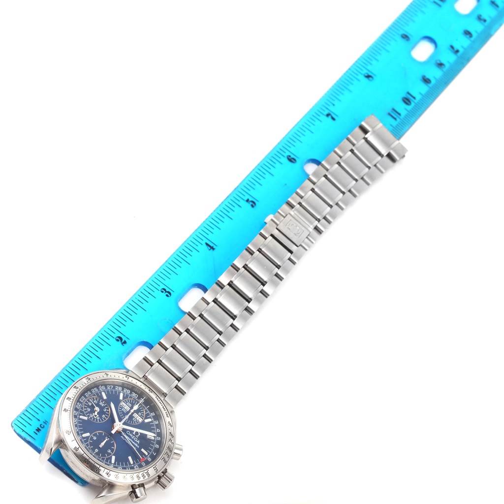 The image shows an Omega Speedmaster 3523.80.00 Men
s Stainless Steel Blue Dial 3523.80.00 Men
s Stainless Steel Blue Dial watch, its face, and metallic band, placed next to a blue ruler for size reference.