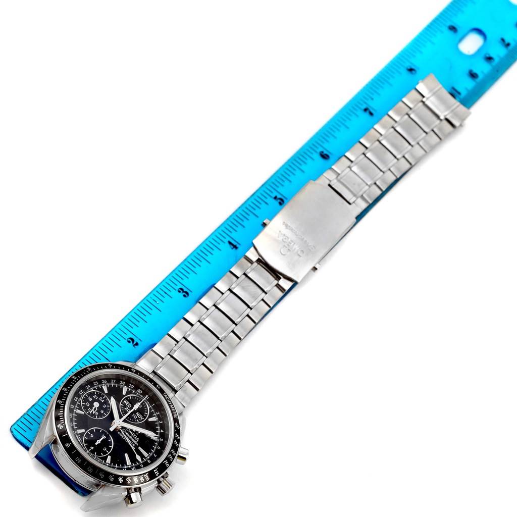 The Omega Speedmaster 3220.50.00 Men
s Stainless Steel Black Dial 3220.50.00 Men
s Stainless Steel Black Dial watch is shown from an overhead angle, featuring its face, bracelet, and a blue measuring ruler for scale.