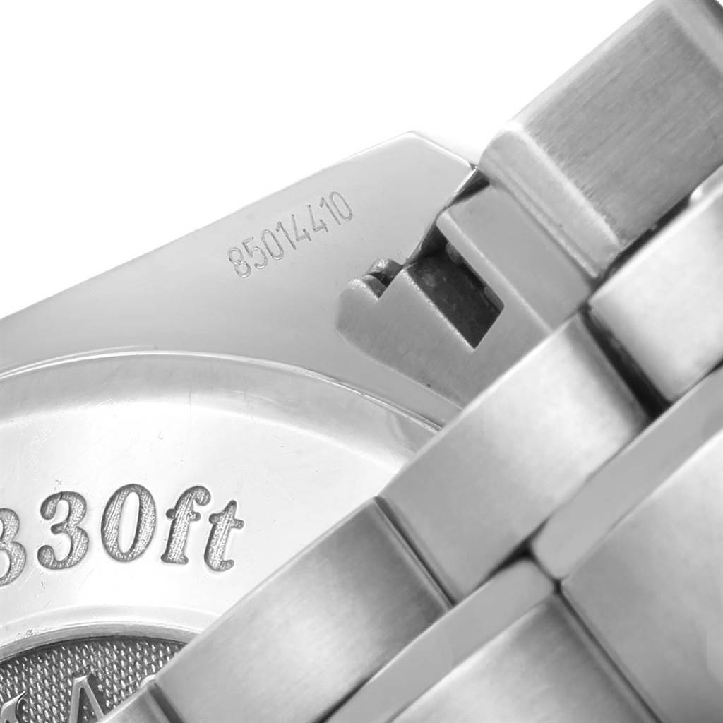 The image shows a close-up of the case back and bracelet of the Omega Speedmaster 3210.50.00 Men
s Stainless Steel Black Dial 3210.50.00 Men
s Stainless Steel Black Dial watch, featuring the engraved depth rating and serial number.