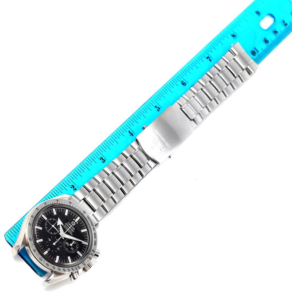 The Omega Speedmaster 3551.50.00 Men
s Stainless Steel Black Dial 3551.50.00 Men
s Stainless Steel Black Dial watch is shown from an overhead angle with its full bracelet extended next to a blue ruler.