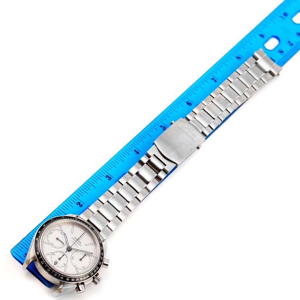 The image shows an Omega Speedmaster 326.30.40.50.02.001 Men
s Stainless Steel White Dial 326.30.40.50.02.001 Men
s Stainless Steel White Dial watch with a stainless steel bracelet and clasp, laid next to a blue ruler for scale.