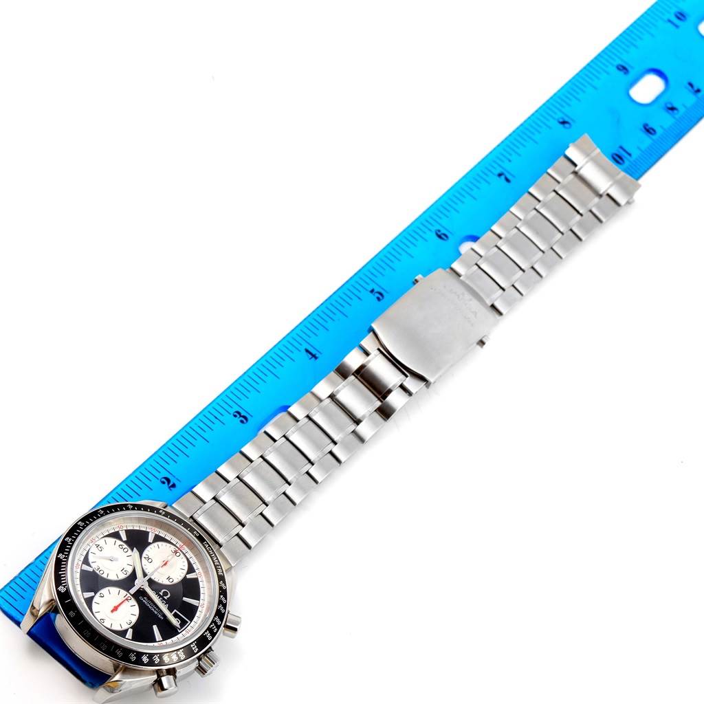 The image shows an Omega Speedmaster 3210.51.00 Men
s Stainless Steel Black Dial 3210.51.00 Men
s Stainless Steel Black Dial watch laid flat next to a ruler, displaying its face, bezel, and metal bracelet.