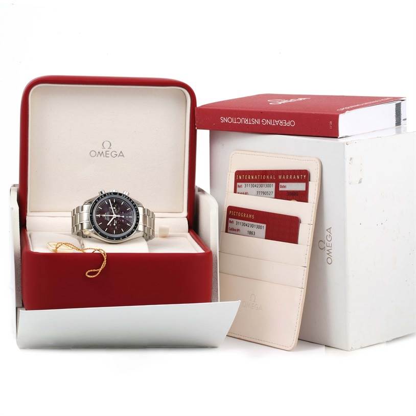 This image shows an Omega Speedmaster 311.30.42.30.13.001 Men's Stainless Steel Brown Dial 311.30.42.30.13.001 Men's Stainless Steel Brown Dial watch in its red box, with warranty cards and operating instructions beside it.