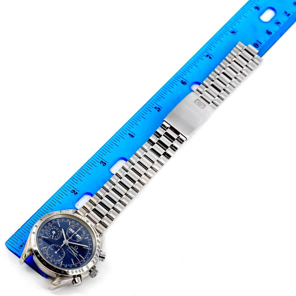 This image shows an Omega Speedmaster 3521.80.00 Men
s Blue Dial 3521.80.00 Men
s Blue Dial watch at a top-down angle, alongside a blue ruler for measurement.