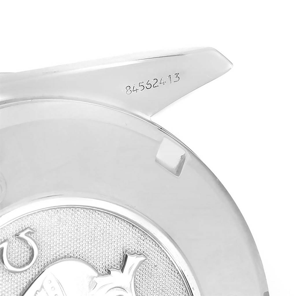 The image shows the back case of the Omega Speedmaster 3210.50.00 Men
s Stainless Steel Black Dial 3210.50.00 Men
s Stainless Steel Black Dial watch, including the engraved serial number and part of the emblem.