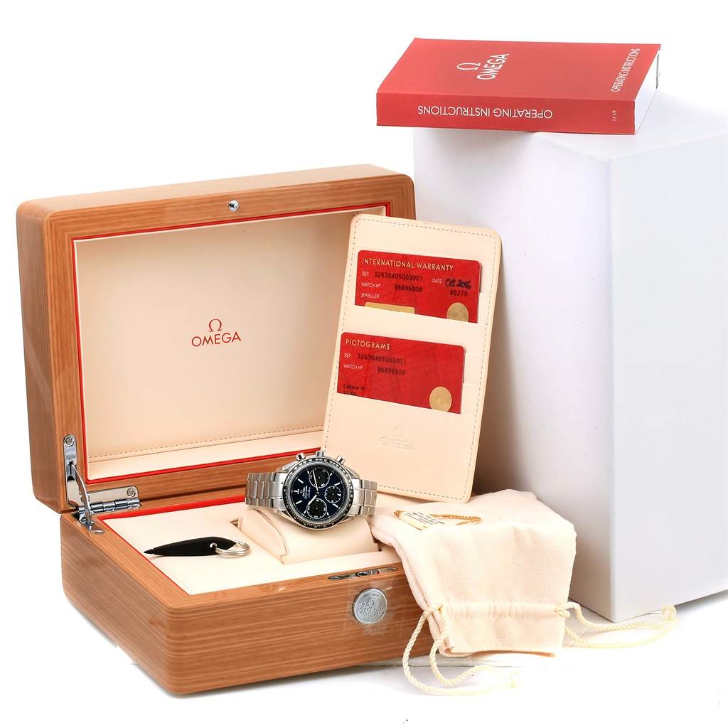 The image shows an Omega Speedmaster 326.30.40.50.03.001 Men's Stainless Steel Blue Dial 326.30.40.50.03.001 Men's Stainless Steel Blue Dial watch in its open wooden box, along with warranty cards, a manual book, and a cloth pouch.