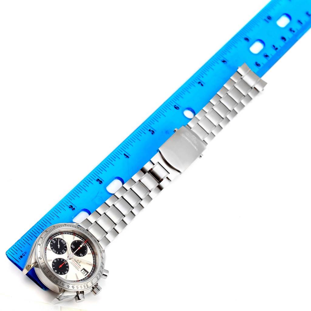 The image shows an Omega Speedmaster 3211.31.00 Men
s Stainless Steel Silver Dial 3211.31.00 Men
s Stainless Steel Silver Dial watch laid out flat next to a blue ruler, highlighting the watch face, bracelet, and clasp.