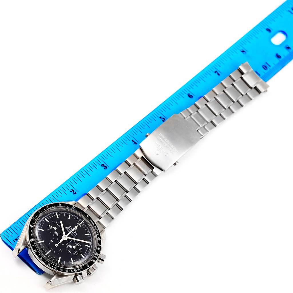 The Omega Speedmaster 3572.50.00 Men
s Stainless Steel Black Dial 3572.50.00 Men
s Stainless Steel Black Dial watch is shown from a top-down angle, displaying its face, bezel, and metal bracelet alongside a ruler for scale.