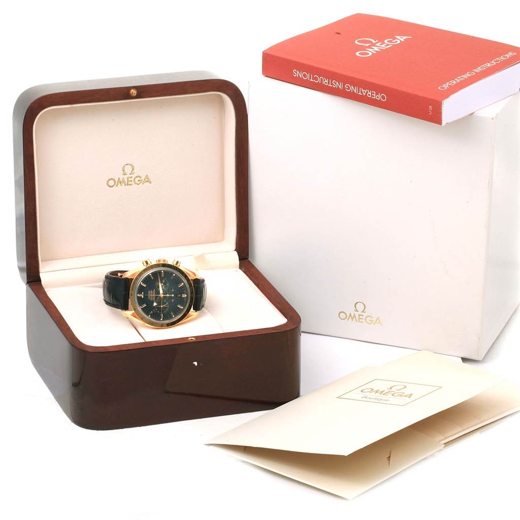 The Omega Speedmaster 178.0022 Men's Blue Dial 178.0022 Men's Blue Dial watch is shown at an angle inside an open wooden box, alongside its operating instructions and packaging.