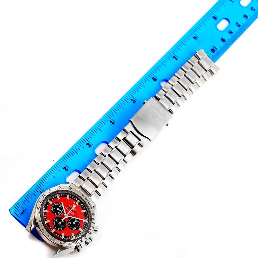 This image shows an Omega Speedmaster 3506.61.00 Men's Stainless Steel Red Dial 3506.61.00 Men's Stainless Steel Red Dial watch with a metal bracelet laid adjacent to a ruler for measurement.