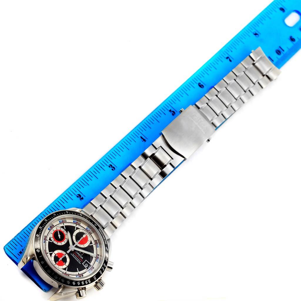 The image shows a top-down view of an Omega Speedmaster 3210.52.00 Men
s Stainless Steel Black Dial 3210.52.00 Men
s Stainless Steel Black Dial watch with its metal bracelet next to a blue ruler for scale.