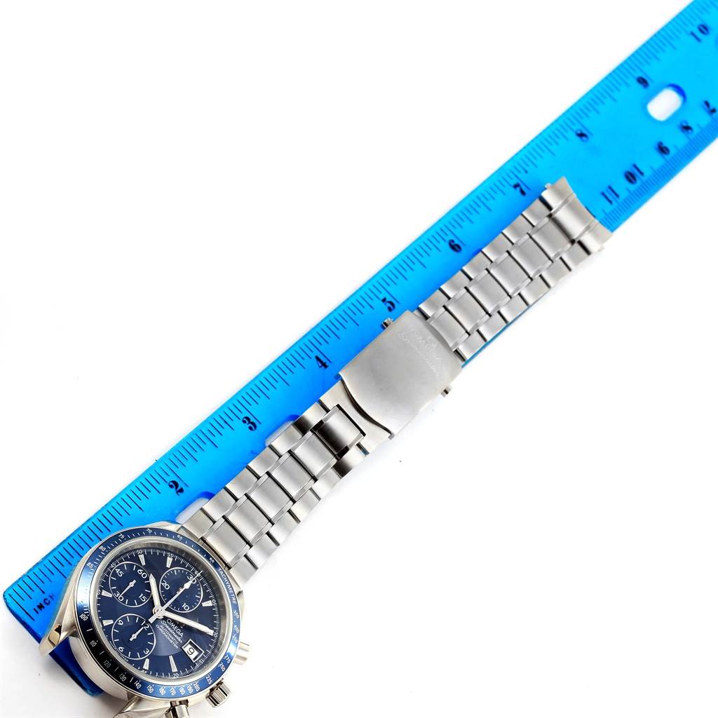The image shows an Omega Speedmaster 3212.80.00 Men
s Stainless Steel Blue Dial 3212.80.00 Men
s Stainless Steel Blue Dial watch laid next to a blue ruler for measurement, revealing the dial and bracelet.