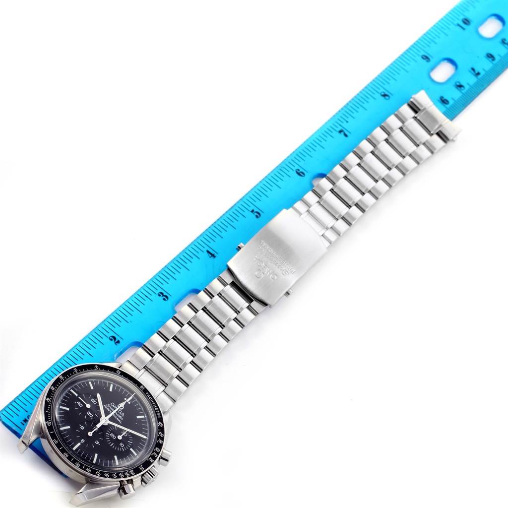 The Omega Speedmaster 3570.50.00 Men
s Stainless Steel Black Dial 3570.50.00 Men
s Stainless Steel Black Dial watch is shown laid flat next to a ruler, displaying its face and metal bracelet.