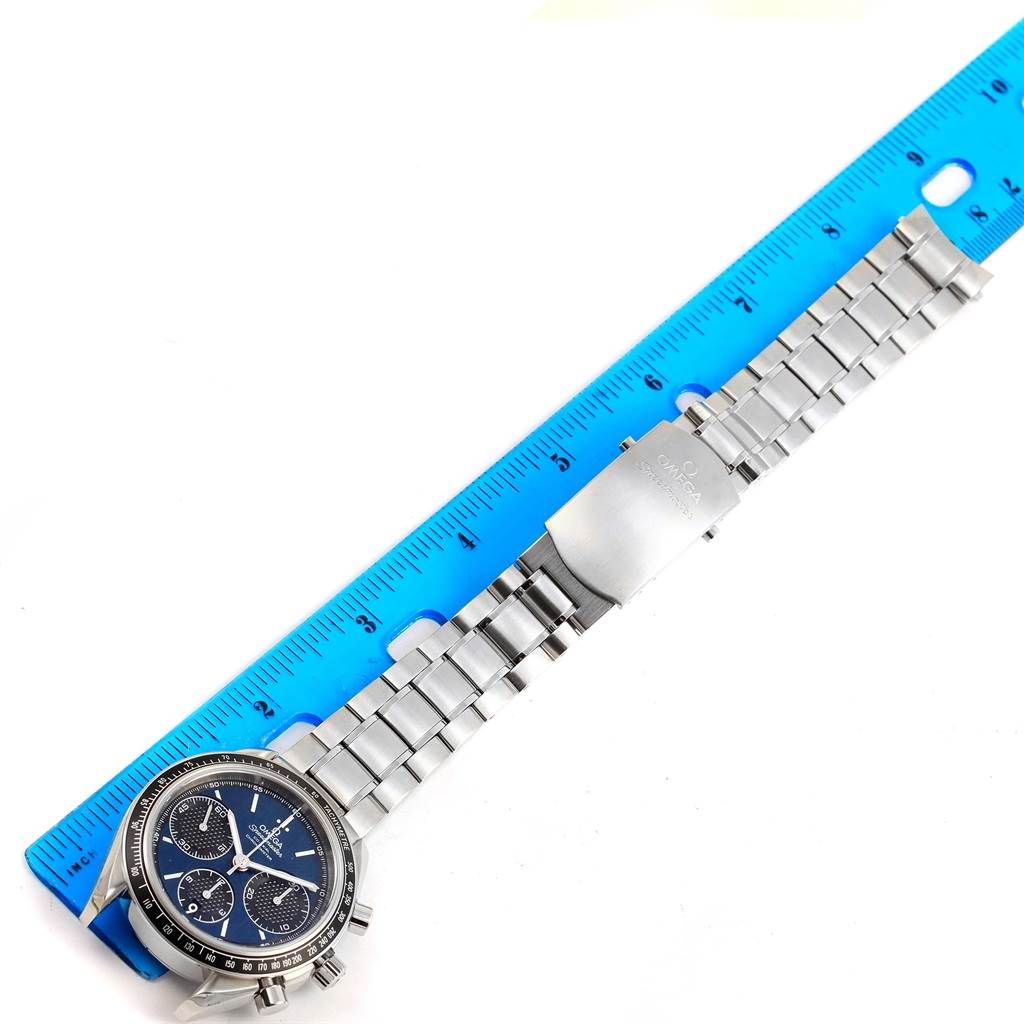 The Omega Speedmaster 326.30.40.50.03.001 Men
s Stainless Steel Blue Dial 326.30.40.50.03.001 Men
s Stainless Steel Blue Dial watch is displayed flat, alongside a blue ruler, showing the face, band, and clasp.