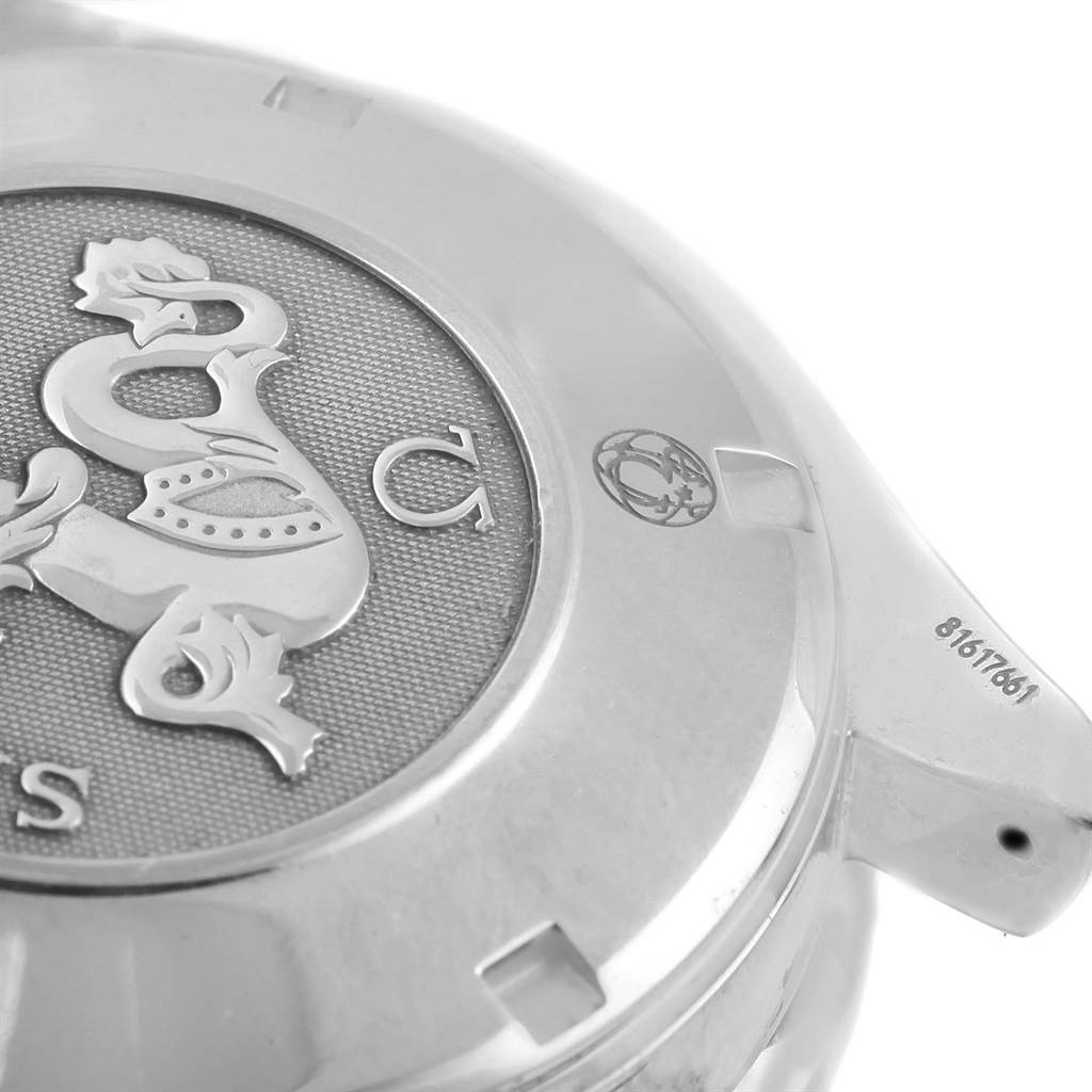 The image shows a partial view of the back case of an Omega Speedmaster 3212.80.00 Men
s Stainless Steel Blue Dial 3212.80.00 Men
s Stainless Steel Blue Dial watch with an engraved logo and some serial numbers.