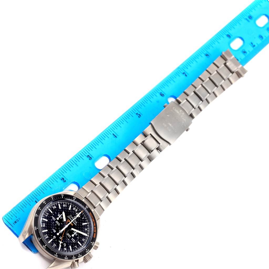 This image shows an Omega Speedmaster 321.90.44.52.01.001 Men's Titanium Black Dial 321.90.44.52.01.001 Men's Titanium Black Dial watch laid flat, face and bracelet visible, alongside a blue ruler for scale.