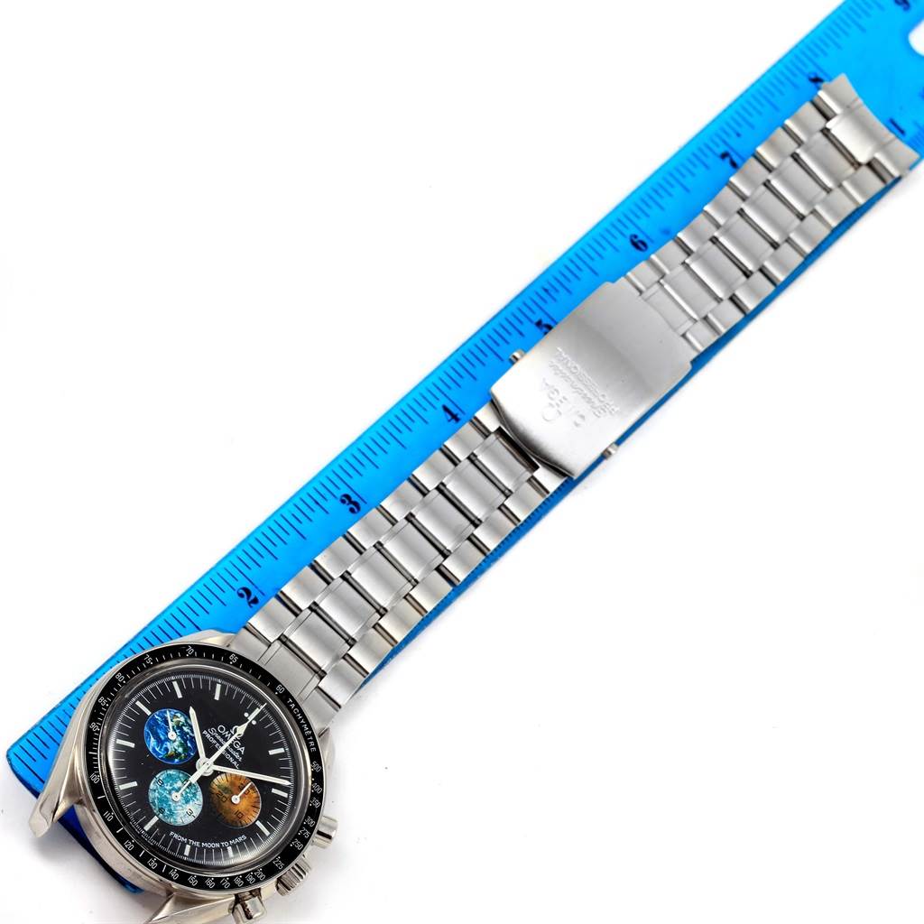 The Omega Speedmaster 3577.50.00 Men's Stainless Steel Black Dial 3577.50.00 Men's Stainless Steel Black Dial watch is shown from above, displaying its face, bezel, and full metal bracelet, positioned alongside a ruler.