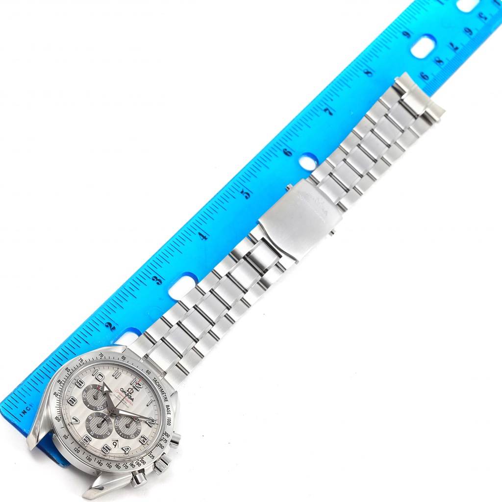 The image shows a top-down view of an Omega Speedmaster 321.10.44.50.02.001 Men's Stainless Steel Silver Dial 321.10.44.50.02.001 Men's Stainless Steel Silver Dial watch, highlighting the face, bezel, and metal bracelet next to a measuring ruler.