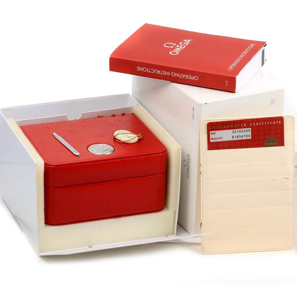 The image shows the packaging and accessories for an Omega Speedmaster 3210.52.00 Men
s Stainless Steel Black Dial 3210.52.00 Men
s Stainless Steel Black Dial, including a red box, instruction manual, and chronometer certificate.