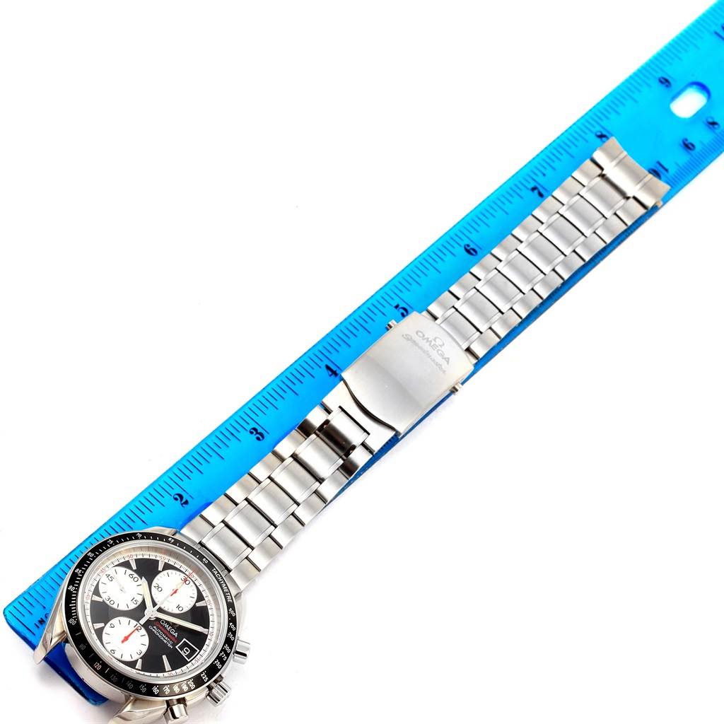 The Omega Speedmaster 3210.51.00 Men
s Stainless Steel Black Dial 3210.51.00 Men
s Stainless Steel Black Dial watch is laid flat, showing its face, bracelet, and clasp, with a ruler for scale comparison.